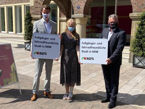 Gruppe von drei Menschen stehen vor den Eingang des Rathauses
